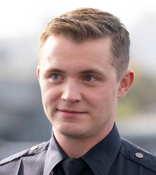 "The Rookie - Die Rückkehr": Draußen auf einem Gelände steht Rookie Seth Ridley (Patrick Keleher) und blickt nach vorn. Er trägt eine dunkle Polizeiuniform