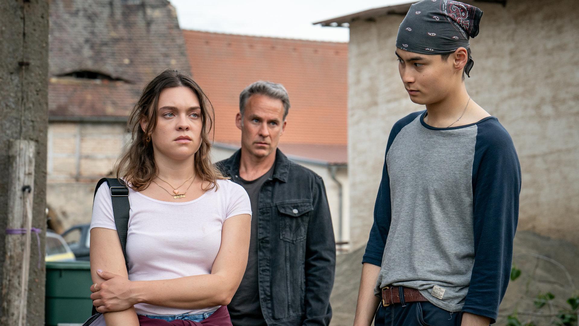 "SOKO Leipzig - Das Leben ist kein Ponyhof": Carina Zadek (Amelie Hennig) steht neben Timo Rönow (Anand Batbileg Chuluunbaatar) und schaut mit traurigem Blick in Richtung Timo. Er schaut sie wiederum betroffen an. Hinter den beiden steht Jan Maybach (Marco Girnth) und beobachtet die Reaktionen der beiden.