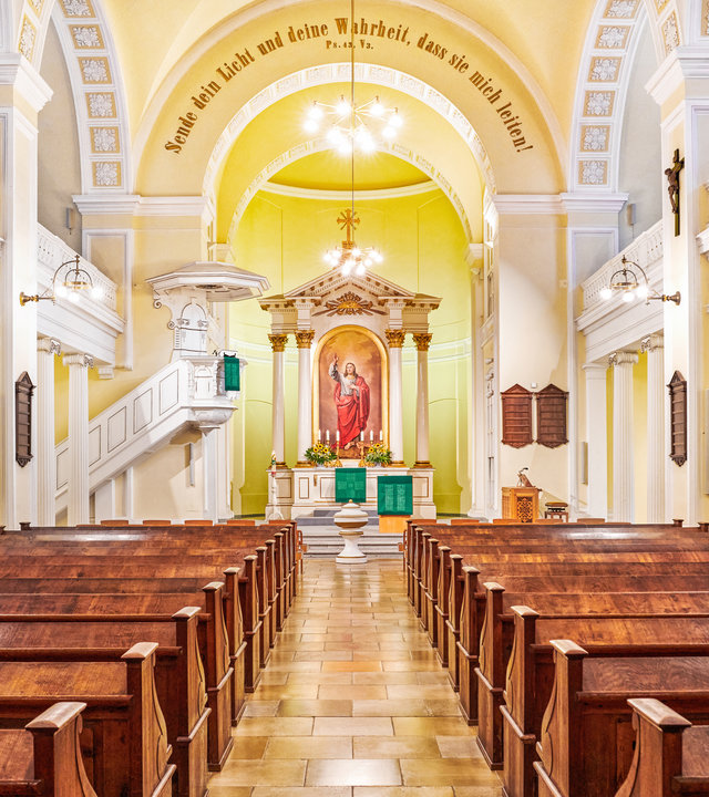 "Evangelischer Gottesdienst - Es lohnt sich": Blick auf das Holzgestühl in Richtung Altar in der Martin-Luther-Kirche in Linz.