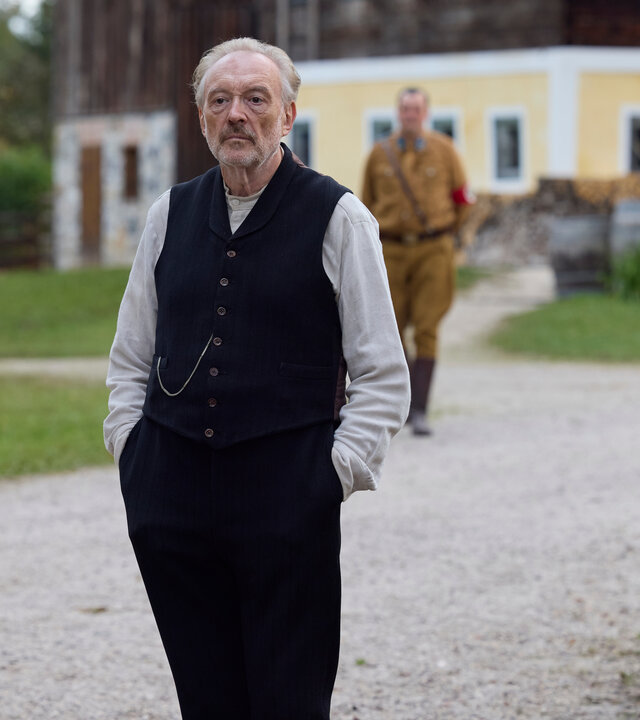 "Sturm kommt auf": Der Schuster Julius Kraus (Josef Hader) steht vor dem Heingeiger Hof, hinter ihm steht Silvan (Sigi Zimmerschied) in SA-Uniform.