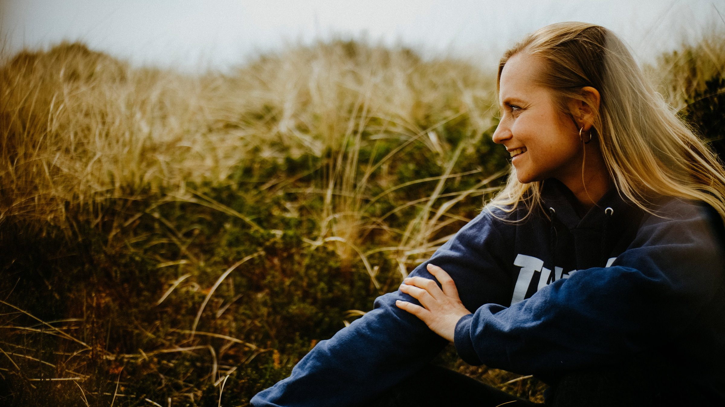 "Happy End auf Zeit - Sarah und ihr Spenderherz": Sarah Angelina sitzt in den Dünen an einem Strand.
