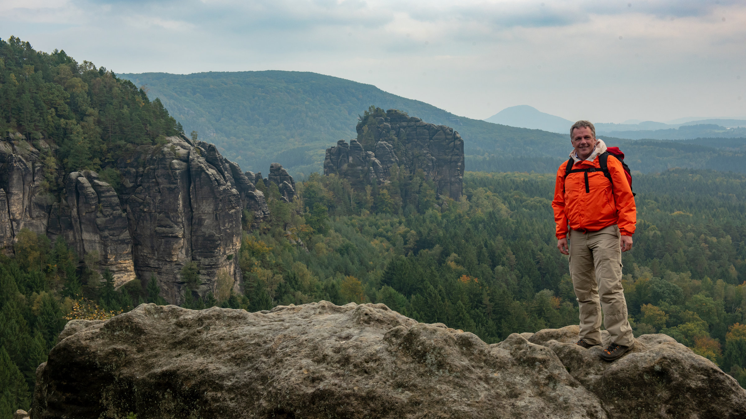 "Terra X: Expedition Europa: Die Verwandlung des Kontinents": Colin Devey steht auf einem Plateau im Elbsandsteingebirge und lacht in die Kamera.