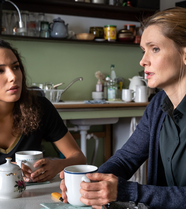 "SOKO Leipzig - Dem Tode geweiht": Kim Nowak (Amy Mußul) sitzt neben Katrin Graber (Alexandra Finder) am Küchentisch in der Küche von Katrin. Beide halten eine Tasse in den Händen. Kim hört Katrin aufmerksam zu.