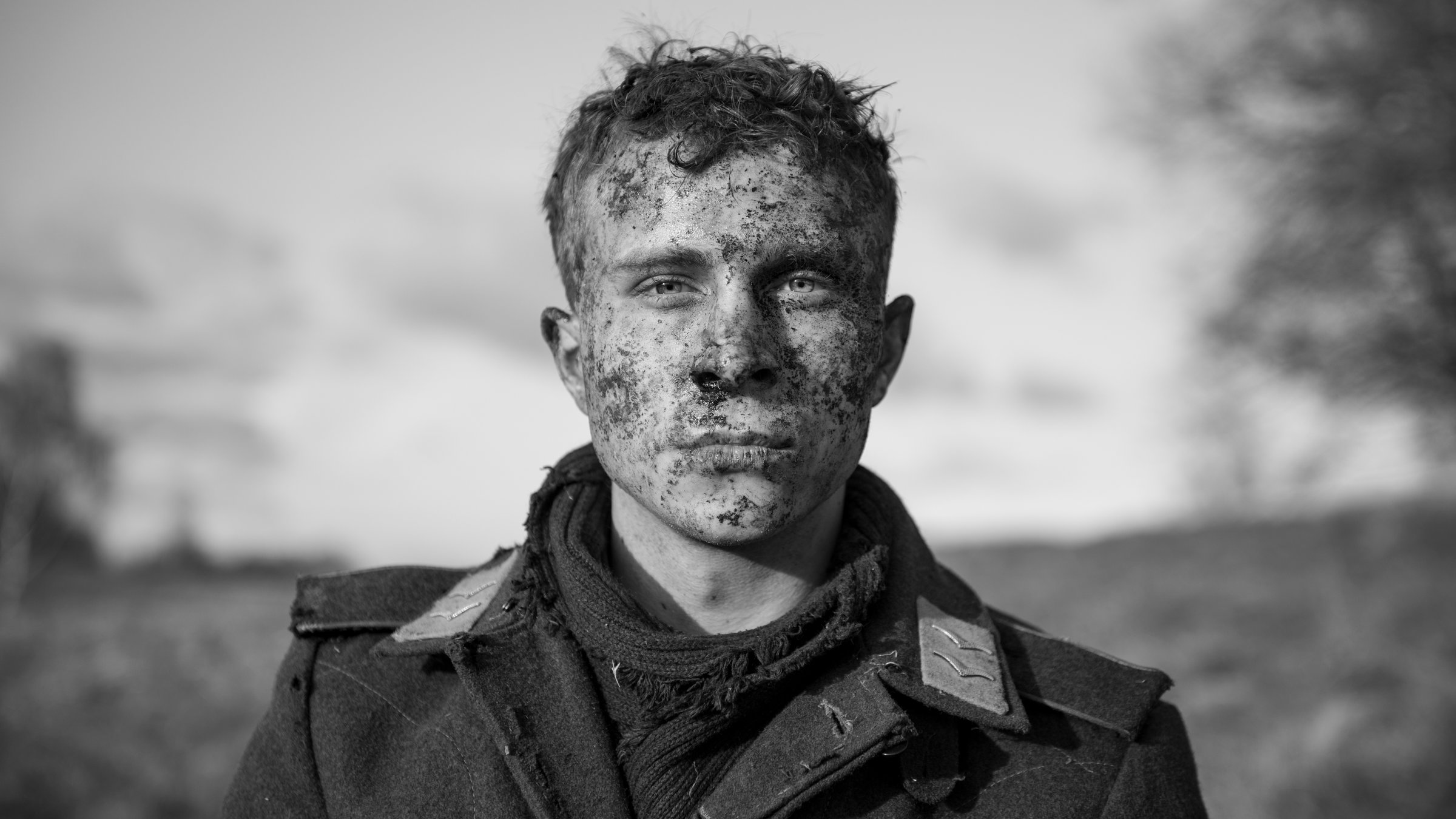 "Der Hauptmann": Ein junger Soldat mit dreckverschmiertem Gesicht und mit offenem Uniformkragen blickt ausdruckslos-abwesend in die Kamera nach vorne.