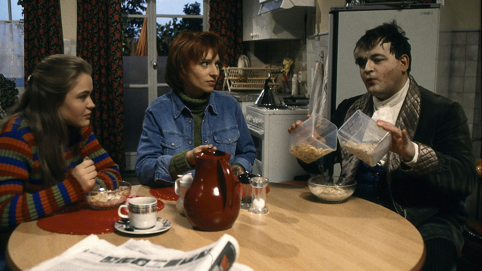 "Sprechstunde bei Dr. Frankenstein": Franzi (Floriane Eichhorn), Charly (Silke Matthias) und Lenni ((Michael Trischan) sitzen beim Frühstück an einem runden Tisch in der Küche.