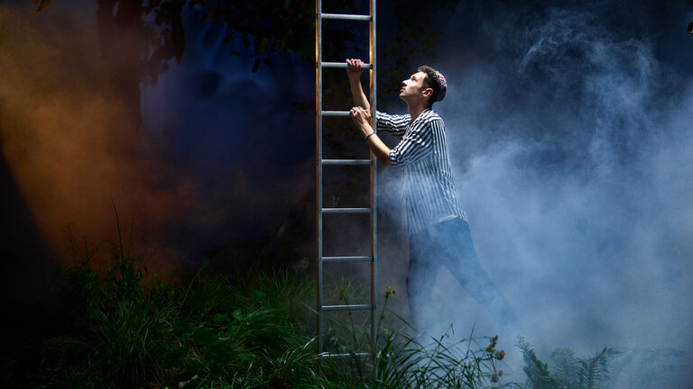 "37°Leben: Against all Gods: Endstation Tod?": Lars steigt im Nebel eine Leiter hinauf. Er trägt dabei seine Kippa.