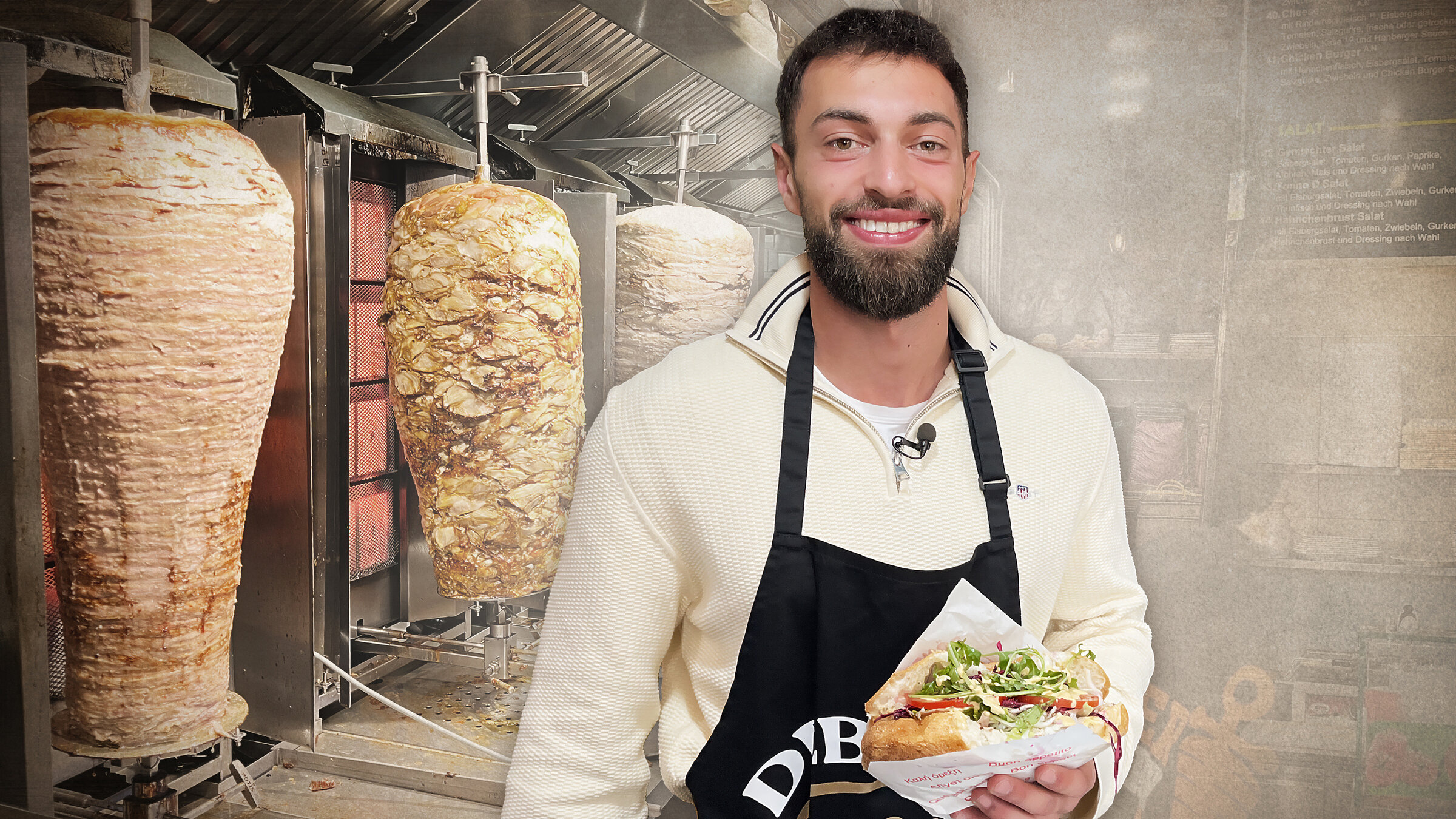 "ZDF.reportage: Der Preis des Döners - Krisenbarometer Imbiss": Dönerimbiss-Besitzer Beshann Ahmadi steht in seinem Geschäft vor mehreren Fleischspießen. In der Hand hält er einen Döner.