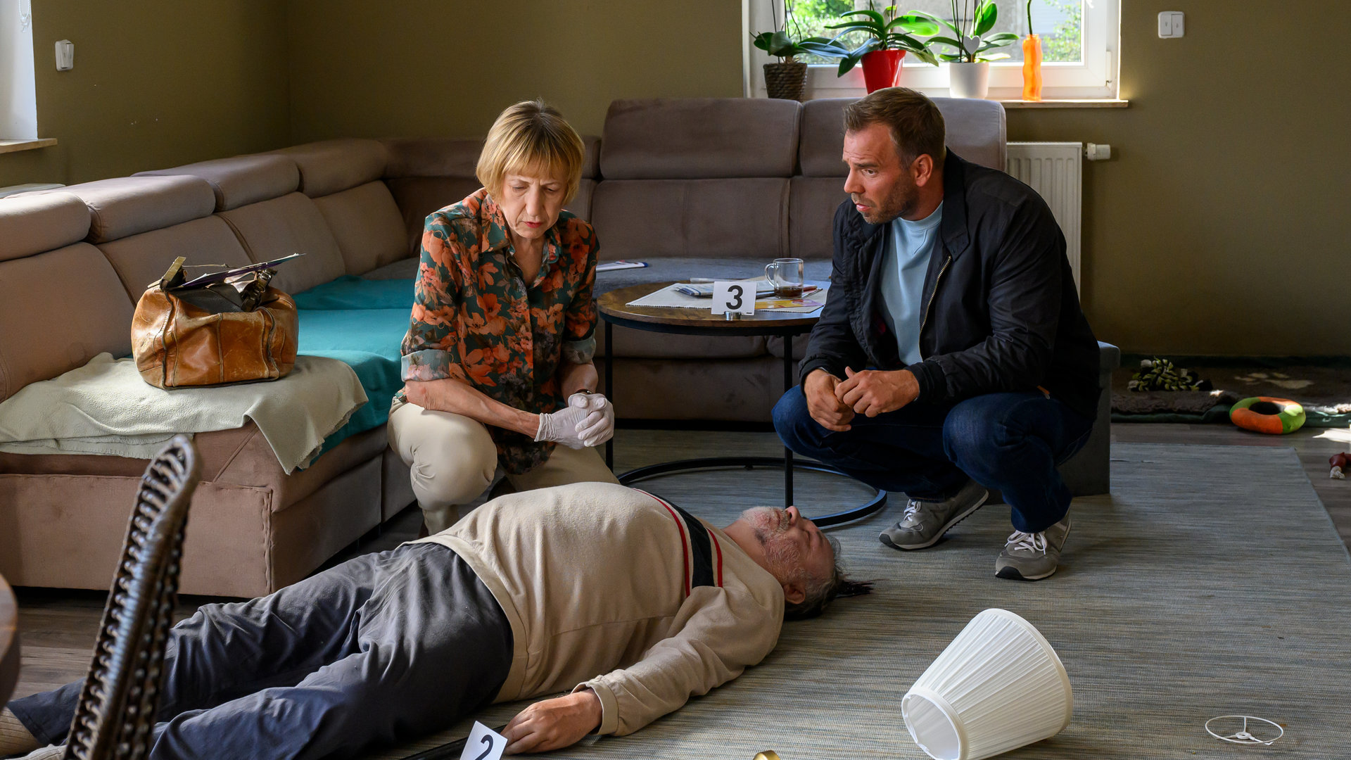 "SOKO Wismar - Wilde Tiere": Dr. Helene Sturbeck (Katharina Blaschke) und Lars Pöhlmann (Dominic Boeer) knieen vor der Leiche Oskar Friedrichs‘ (Bernd Theuerkauf).