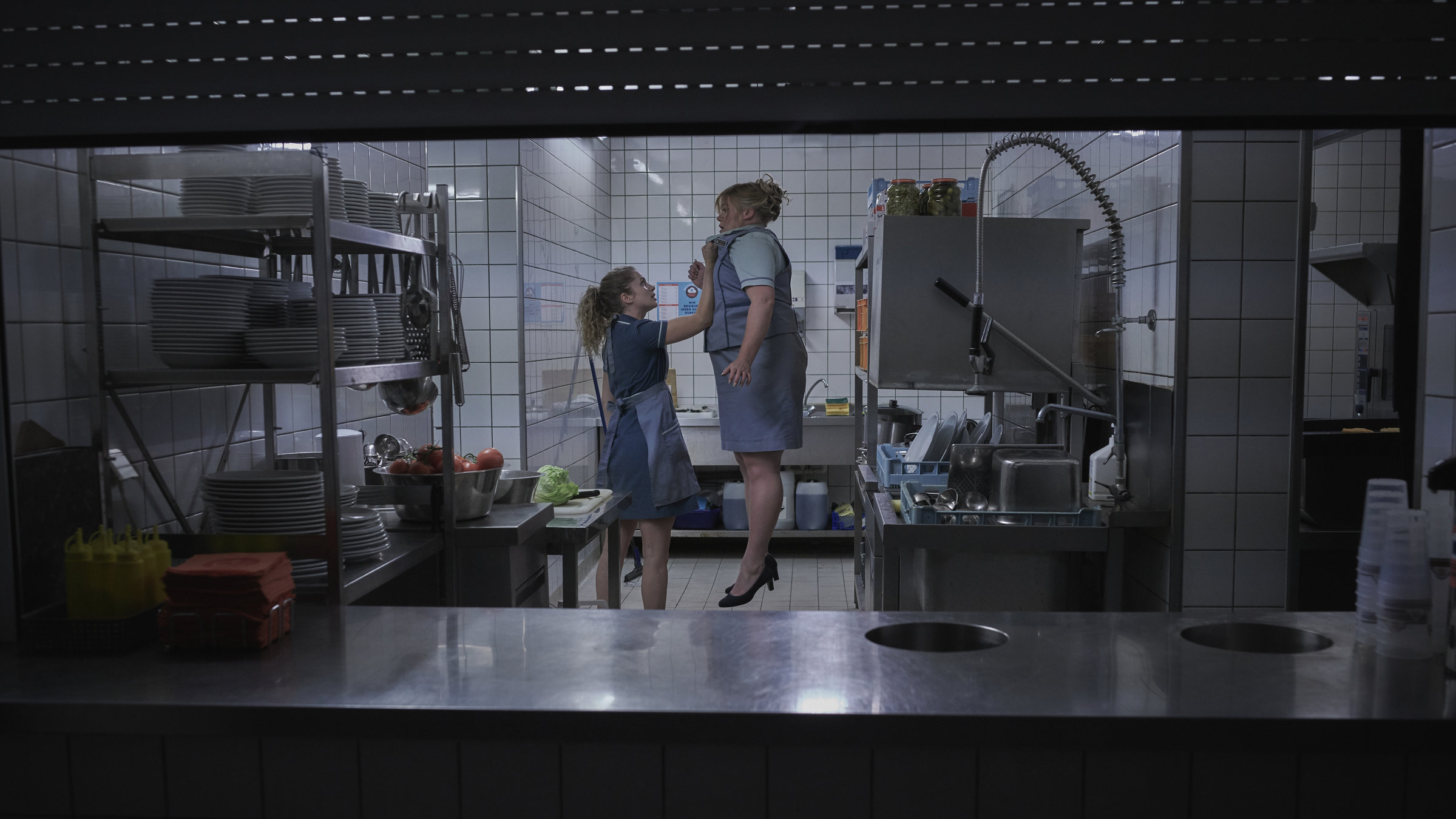 "Freaks - Du bist eine von uns": Wendy (Cornelia Gröschel) hebt in der Küche eines Schnellrestaurants ihre Chefin Angela (Gisa Flake) mühelos mit einem Arm in die Luft.