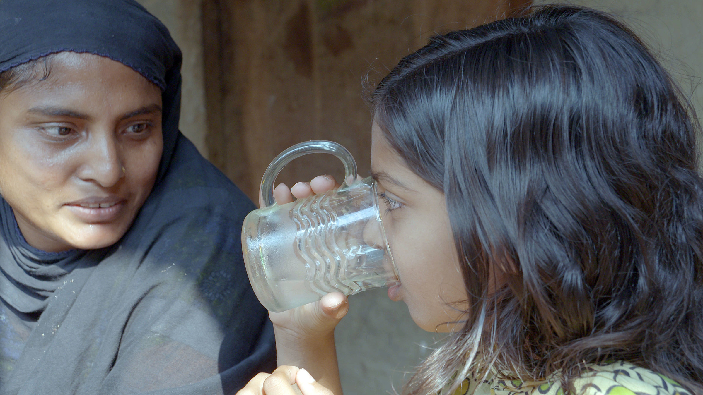 "planet e.: Arsen - der schleichende Tod": Ein Mädchen trinkt gefiltertes Wasser im Beisein ihrer Mutter.