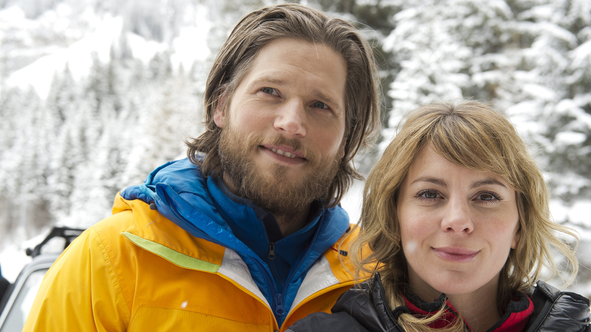 "Die Bergretter - Atemlos (1)": Markus (Sebastian Ströbel) und Katharina (Luise Bähr) stehen nebeneinander in der verschneiten Landschaft und lächeln.