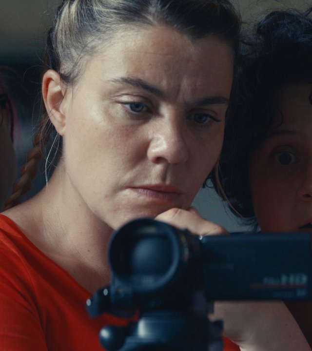 "Derby Girl - Showtime": Mother Blocker (Sophie-Marie Larrouy) hält eine Kamera in ihren Händen. Neben ihr stehen Booby Mercury (Allison Chassagne), Marie-Josée (Salomé Diénis Meulien), Absinthe-ni-touche (Suzanne de Baeque) und Karma (Julia Clavel). Hinter Mother Blocker steht Trash (Adèle Bellanger). Alle Mädchen schauen entsetzt in die Kamera.