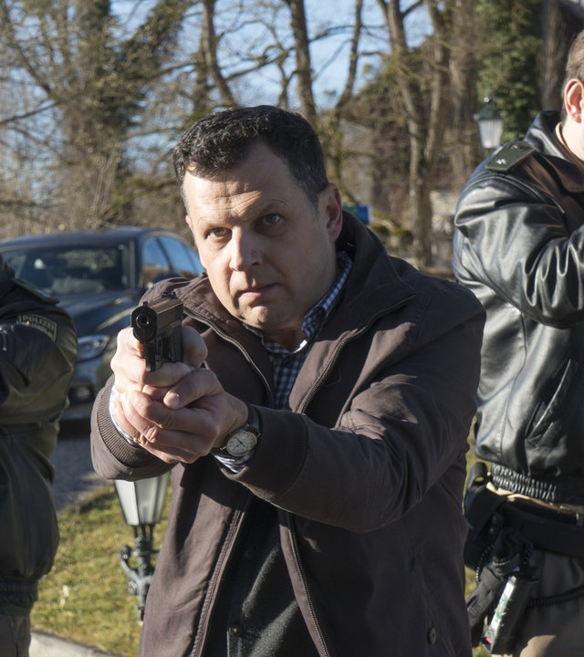 „Laim und die Zeichen des Todes“: Anton Simhandl (Gerhard Wittmann) und seine Kollegen stehen mit vorgehaltenen Waffen auf einem Weg.