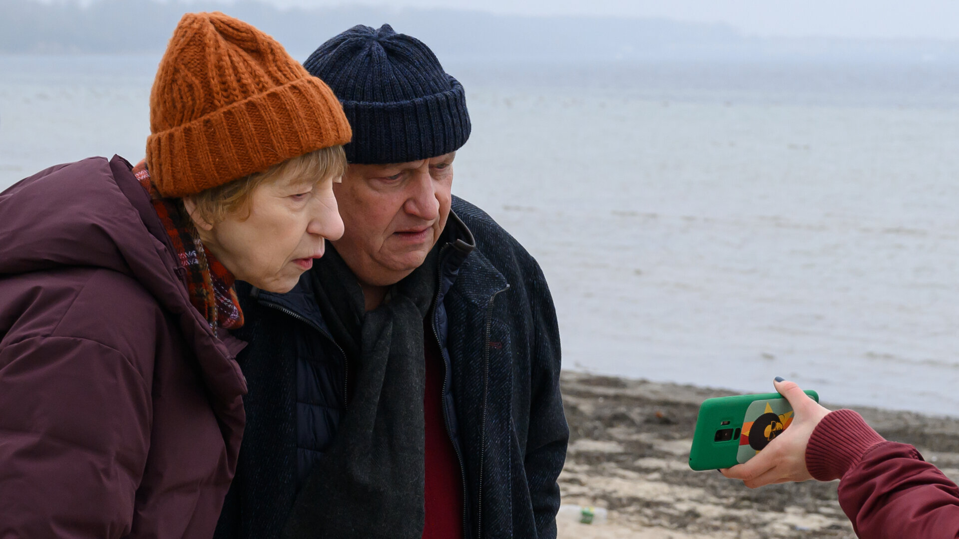 "SOKO Wismar – Schöne Küste": Rechtsmedizinerin Dr. Helene Sturbeck (Katharina Blaschke) und Revierchef Jan-Hinrich Reuter (Udo Kroschwald) betrachten am Strand das Foto der vermissten Nele Köster.