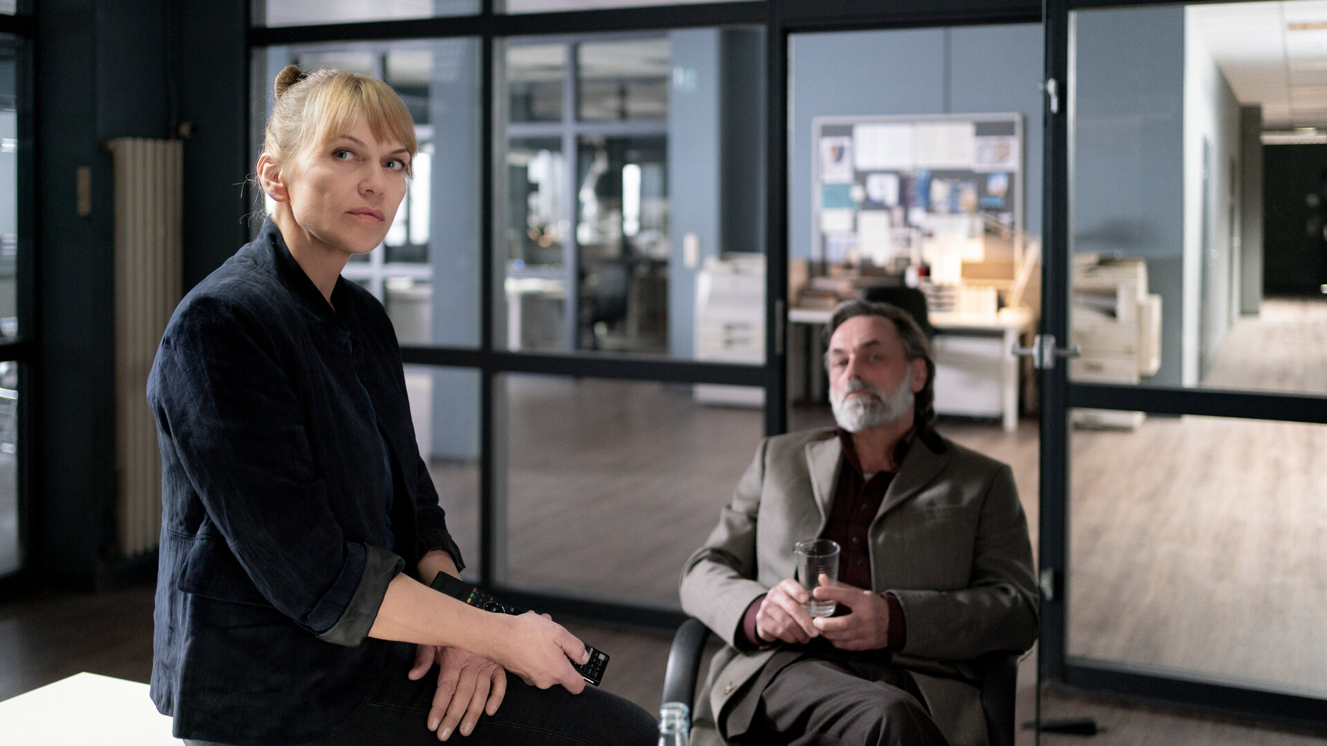 "Helen Dorn - Der deutsche Sizilianer": Toni Vizzante (Peter Benedict) sitzt in Helen Dorns (Anna Loos) Büro. Sie sitzt auf der Schreibtischkante.