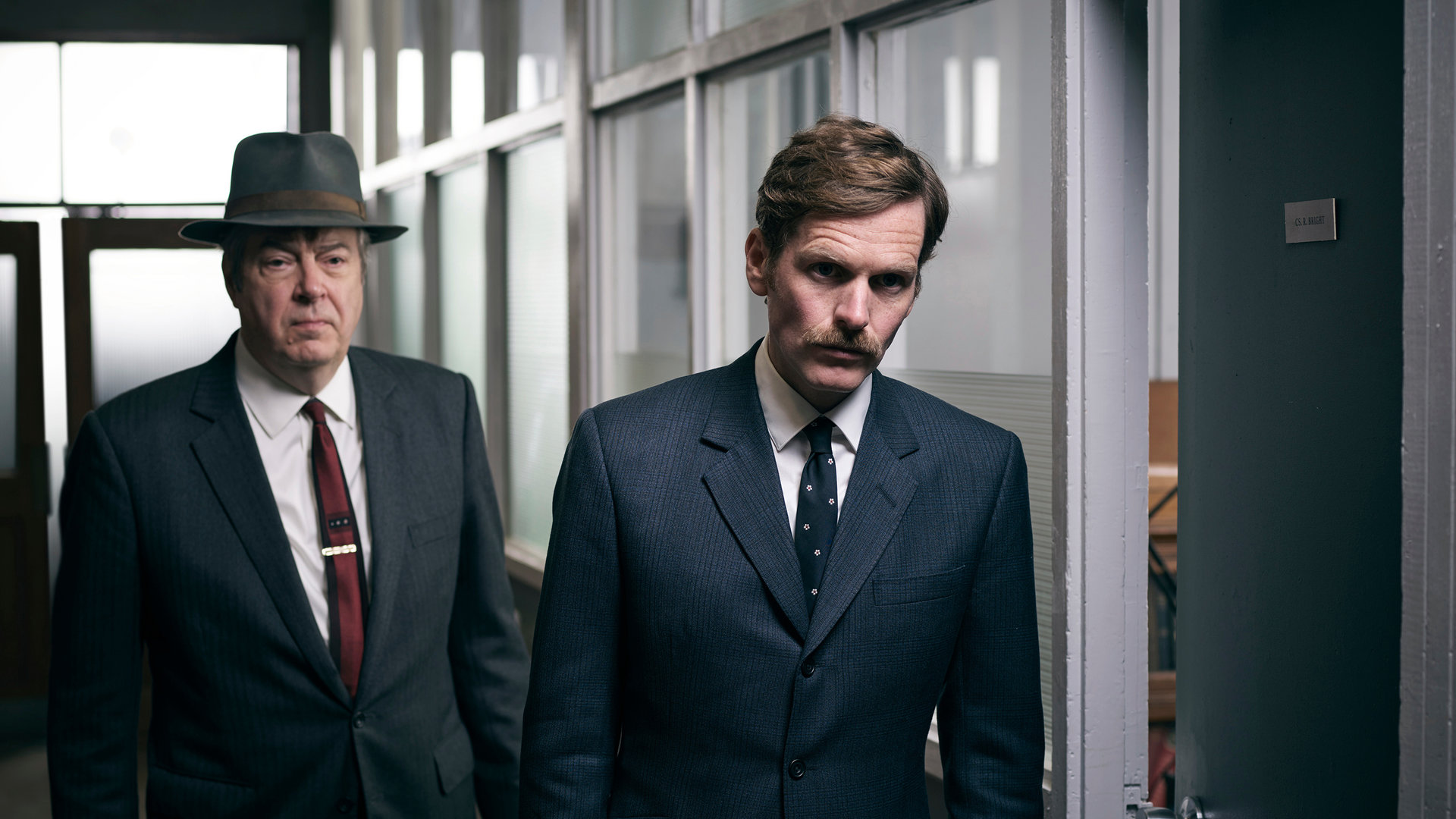 "Der junge Inspektor Morse - Apollo": Endeavour (Shaun Evans) und DI Fred Thursday (Roger Allam) laufen mit ernstem Blick einen Flur entlang.