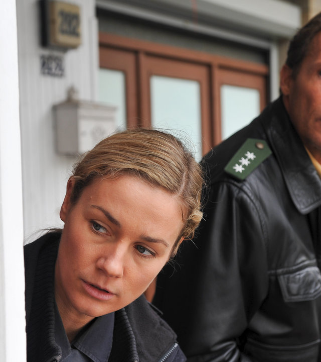 "Notruf Hafenkante - Ein guter Plan": Franzi (Rhea Harder) und Peter (Christian Tramitz) stehen nebeneinander. Sie stehen versteckt in einem Hauseingang und blicken um die Ecke.