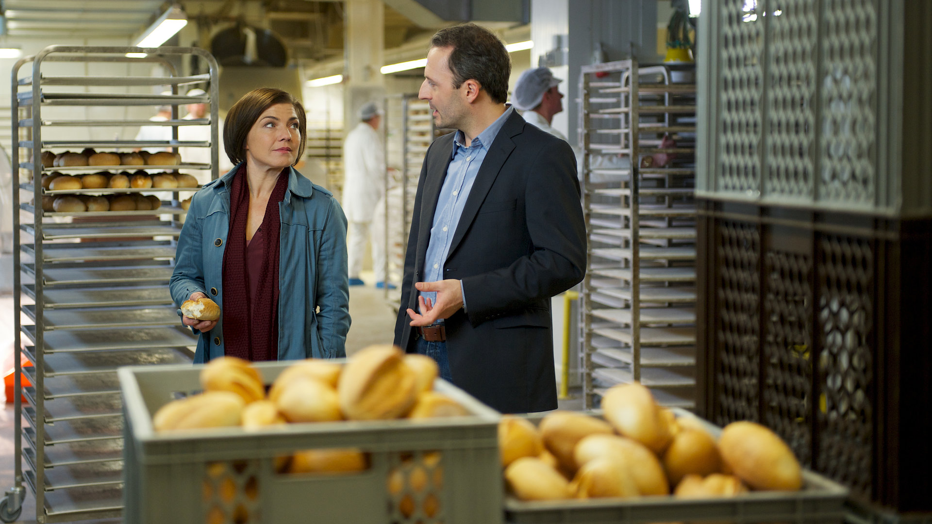 "SOKO Wismar - Ein Zipfel vom Glück": In der Bachstube einer Bäckerei stehen Katrin Börensen (Claudia Schmutzler) und Frank Wiedemann (Robert Schupp) zwischen gefüllten Brötchenkisten und unterhalten sich.