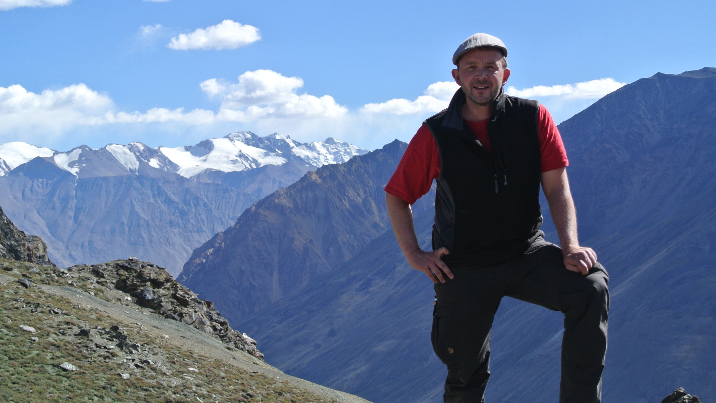 "Im Pamir - Auf dem Dach der Welt": Tourismus-Experte Matthias Poeschel steht weit oben vor einer tollen Bergkulisse.