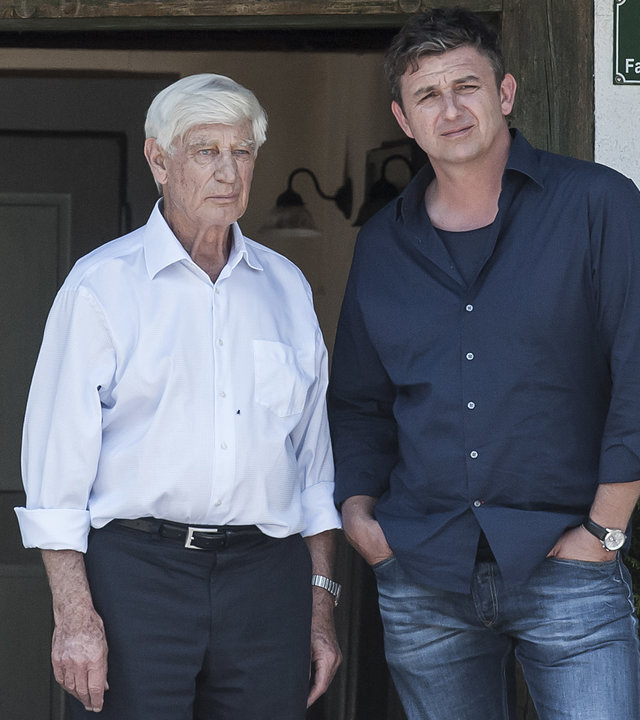 "Der Bergdoktor - Alte Wunden (1)": Dr. Roman Melchinger (Siegfried Rauch) und Dr. Martin Gruber (Hans Sigl) stehen vor der Praxis. Beide schauen grübelnd in die Kamera.