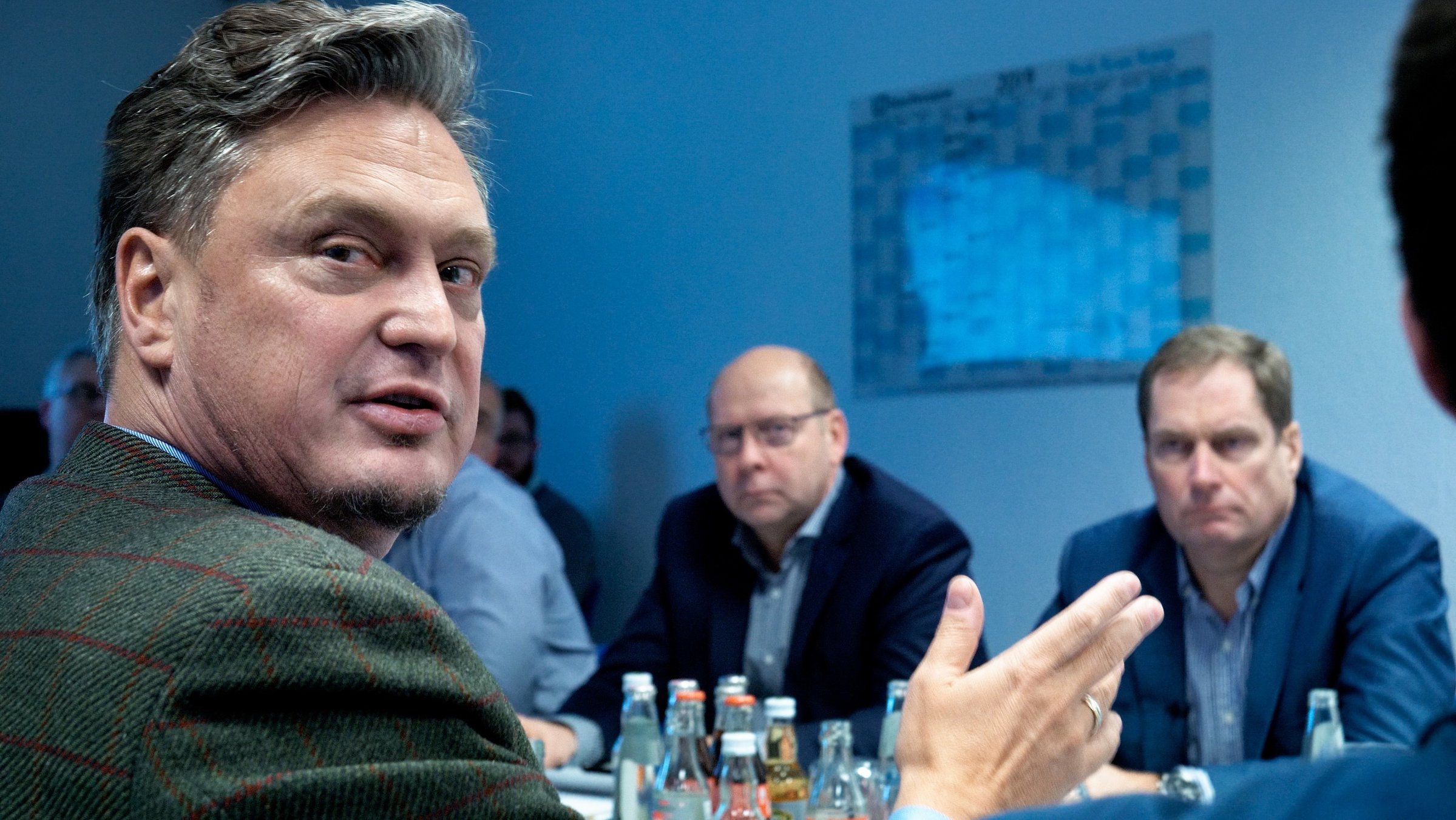 "Eine deutsche Partei": Einige männliche Parteimitglieder der AfD sitzen an einem Besprechungstisch. Einer von ihnen – Frank-Christian Hansel – blickt über seine rechte Schulter direkt in die Kamera.
