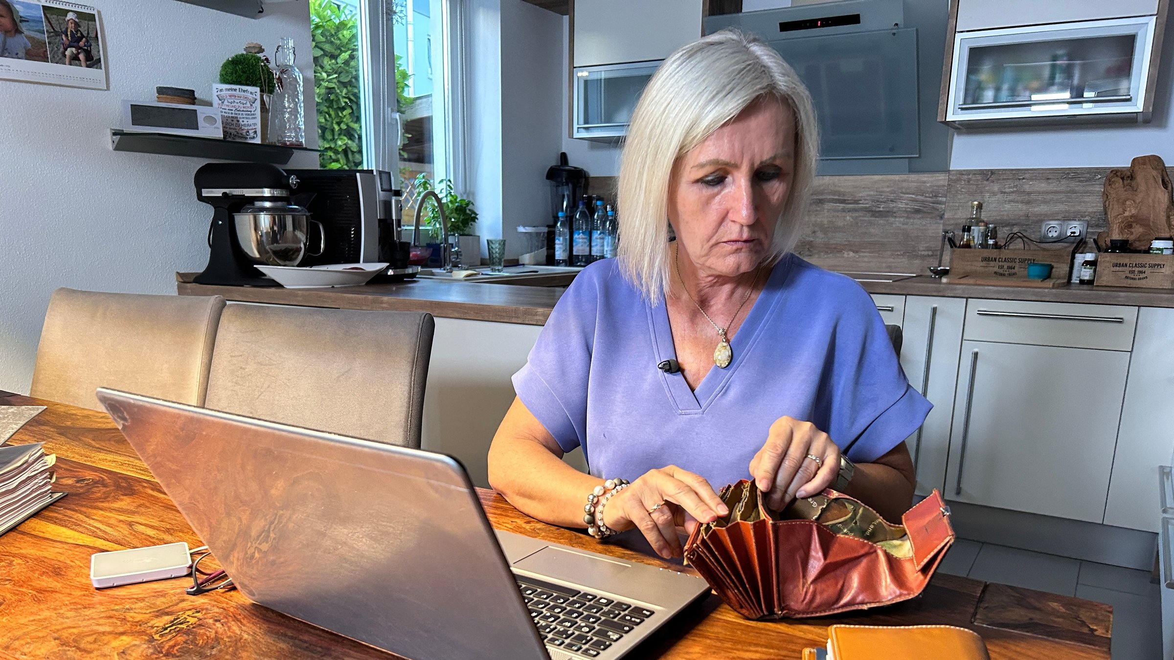 "ZDF.reportage: Armes reiches Deutschland - Selbstständige in Not": Pauline Döring sitzt an ihrem Küchentisch und zählt am Ende des Tages ihre Ausgaben und Einnahmen.