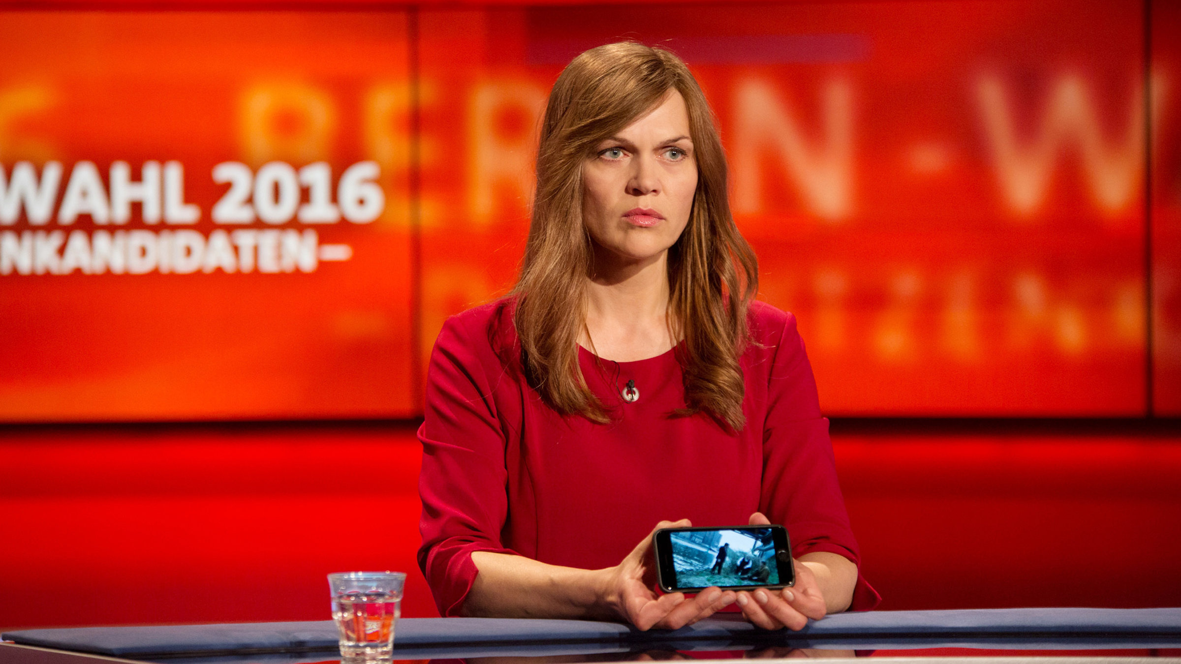 "Die Stadt und die Macht - Alles was ich bin": Susanne Kröhmer (Anna Loos) zeigt in der letzten TV-Debatte vor der Wahl das Handyvideo, das Degenhardts und KKs Auftragsmord beweist.