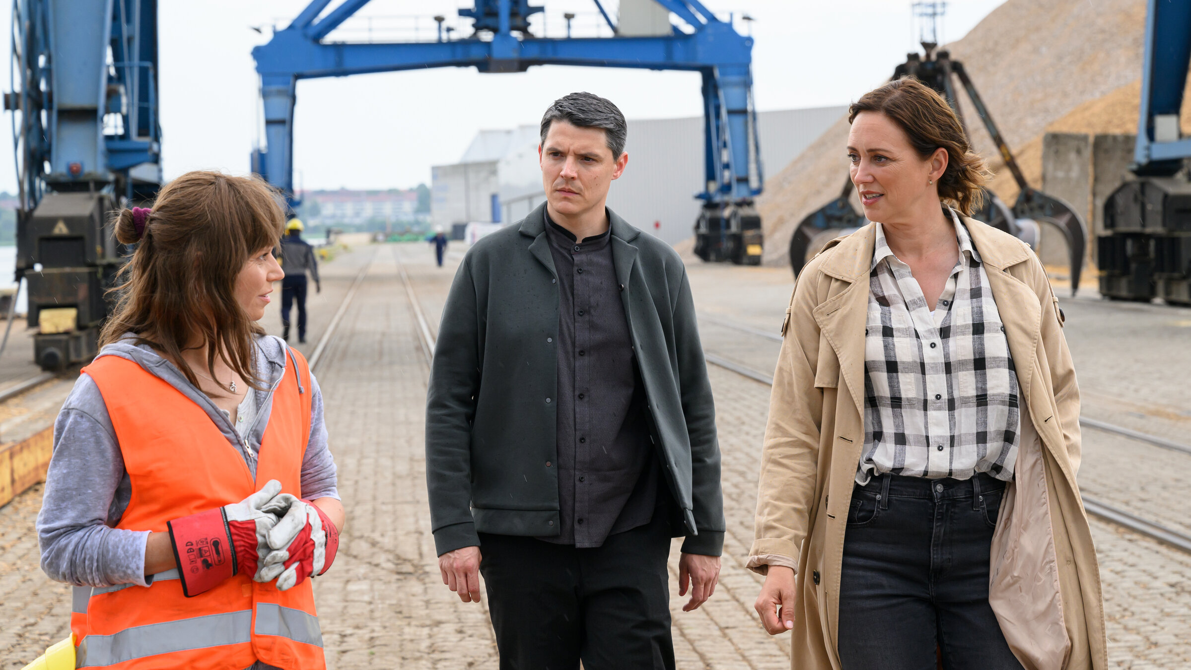 "SOKO Wismar – Die neun Gehirne des Oktopus": Kriminalkommissar Rico Sander (Benjamin Strecker) und Hauptkommissarin Karoline Joost (Nike Fuhrmann) befragen Kranfahrerin Nancy Dorn (Annette Strasser) auf ihrer Arbeitsstelle im Hafen.