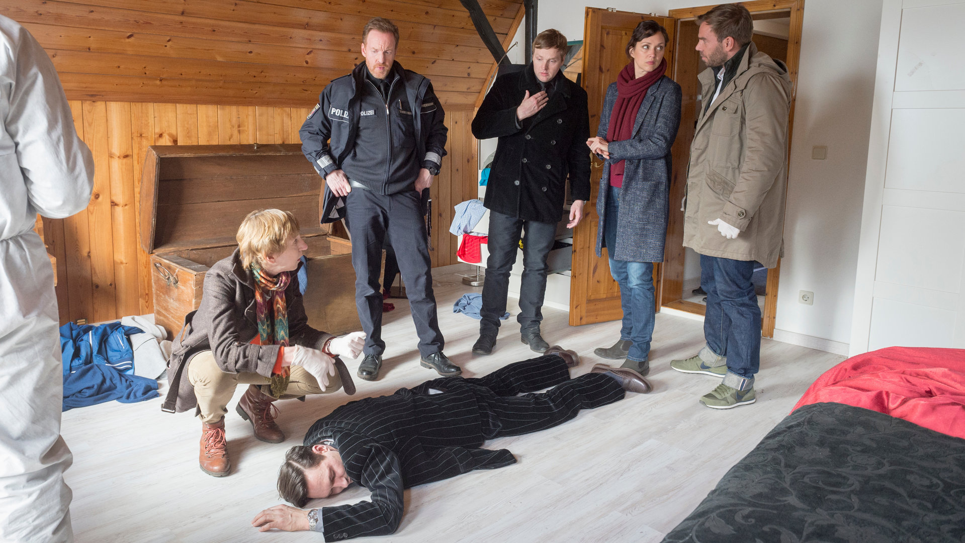 „SOKO Wismar – Leichenschmaus“: Rechtsmedizinerin Helene Sturbeck (Katharina Blaschke) zeigt den Kollegen Pöhlmann (Dominic Boeer), Joost (Nike Fuhrmann) und Timmermann (Mathias Junge) das Opfer (Tino Kieschnik). Der Sohn der Wohnungsbesitzern Ralph (Knud Riepen) steht perplex neben dem SOKO-Team. Spurensicherer: Komparse.