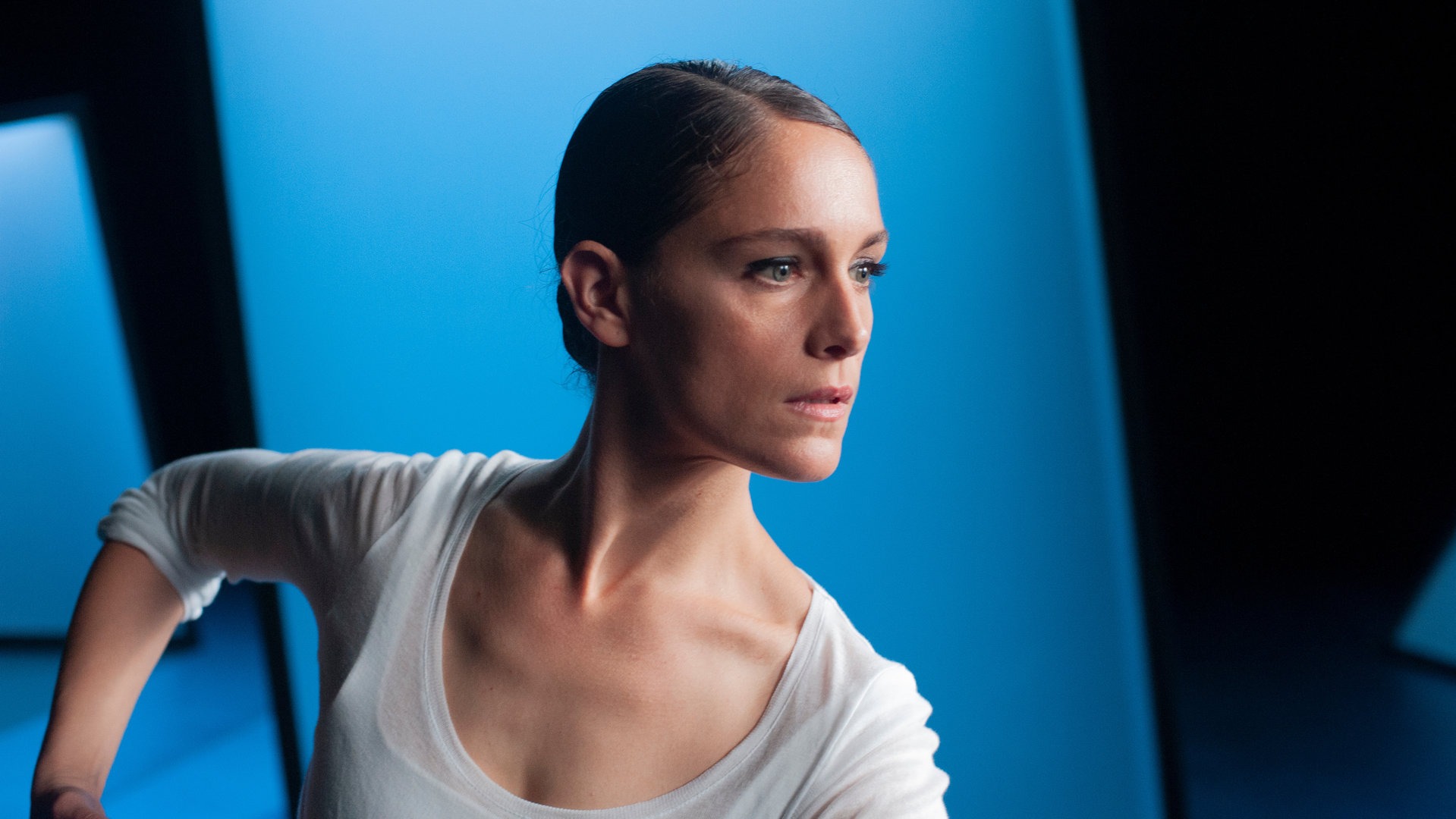 "L'Opéra - Dancing in Paris - Ambitionen": Zoé (Ariane Labed) steht vor blau beleuchteten Requisiten auf einer Bühne und schaut konzentriert in die Ferne.