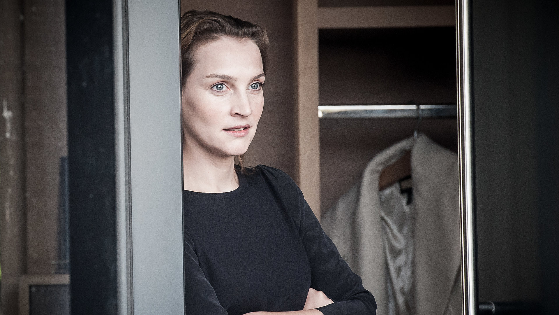 "Der Bergdoktor - Zwei Mütter (1)": Nicole Jenninger (Jana Klinge) an eine Wand gelehnt, blickt gedankenverloren aus dem Fenster.