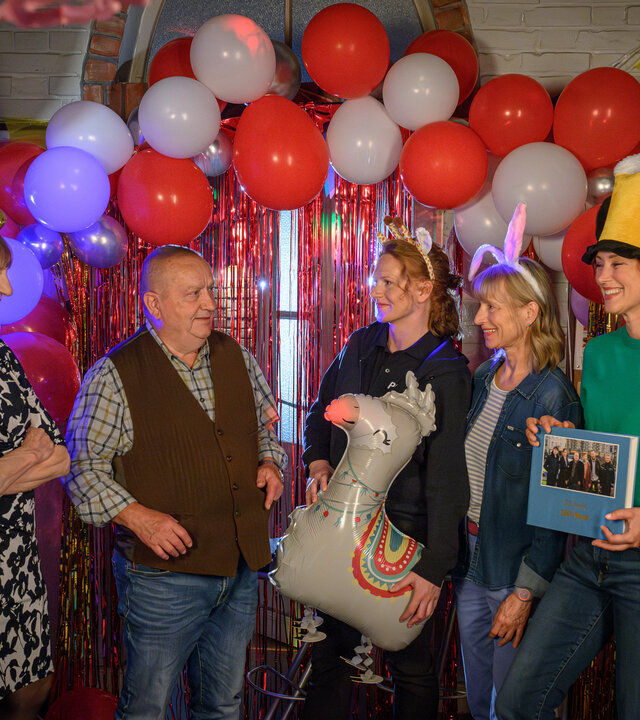 "SOKO Wismar - Reuters Fest": Eddi Jansons (Gustavs Gailus), Dr. Helene Sturbeck (Katharina Blaschke), Paula Moorkamp (Stella Hinrichs), Roswitha Prinzler (Silke Matthias), Karoline Joost (Nike Fuhrmann) und Lars Pöhlmann (Dominic Boeer) gratulieren Revierchef Jan-Hinrich Reuter (Udo Kroschwald) zum 20. Dienstjubiläum.