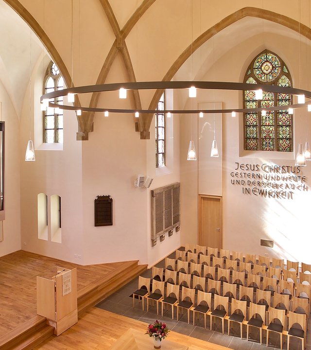 "Evangelischer Gottesdienst - Das Fest beginnt": Blick von schräg oben in das modern und schlicht gehaltene Innere der Petri-Kirche in Herford. Der Boden und das Gestühl sind aus hellem Holz, die modern aussehende Orgel ist hellgrau.