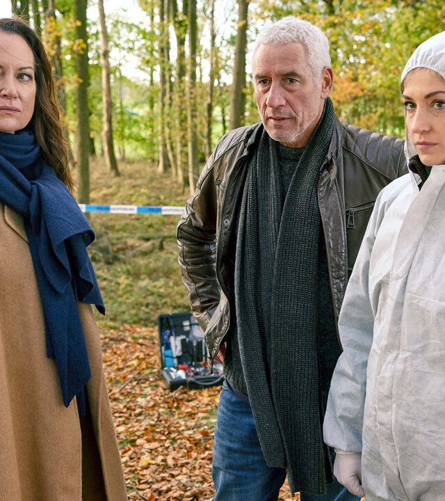 "Unter anderen Umständen - Nordwind": Jana Winter (Natalia Wörner), Matthias Hamm (Ralph Herforth) und Rechtsmedizinerin (Sophia Schubert) stehen an einem Tatort im Wald.
