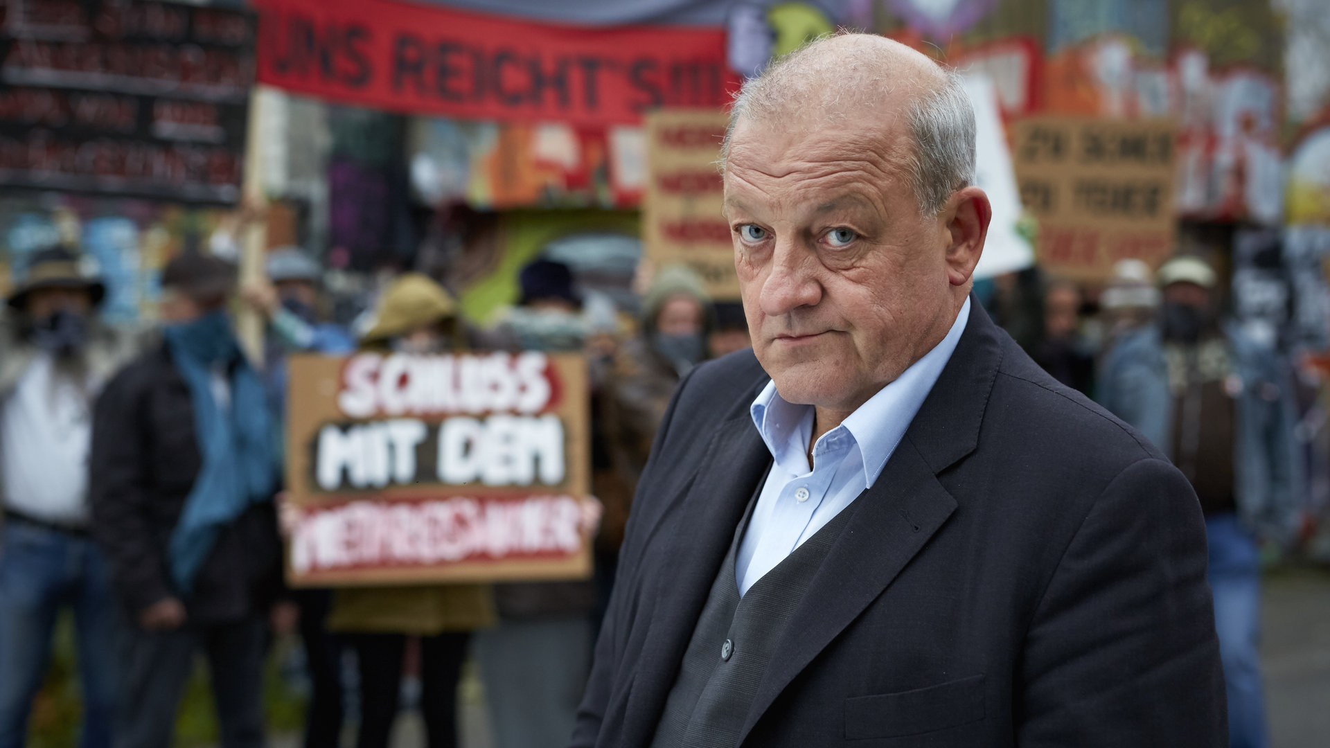 „Wilsberg – Mord und Beton“: Georg Wilsberg (Leonard Lansink) vor Aktivisten im Hafenviertel.