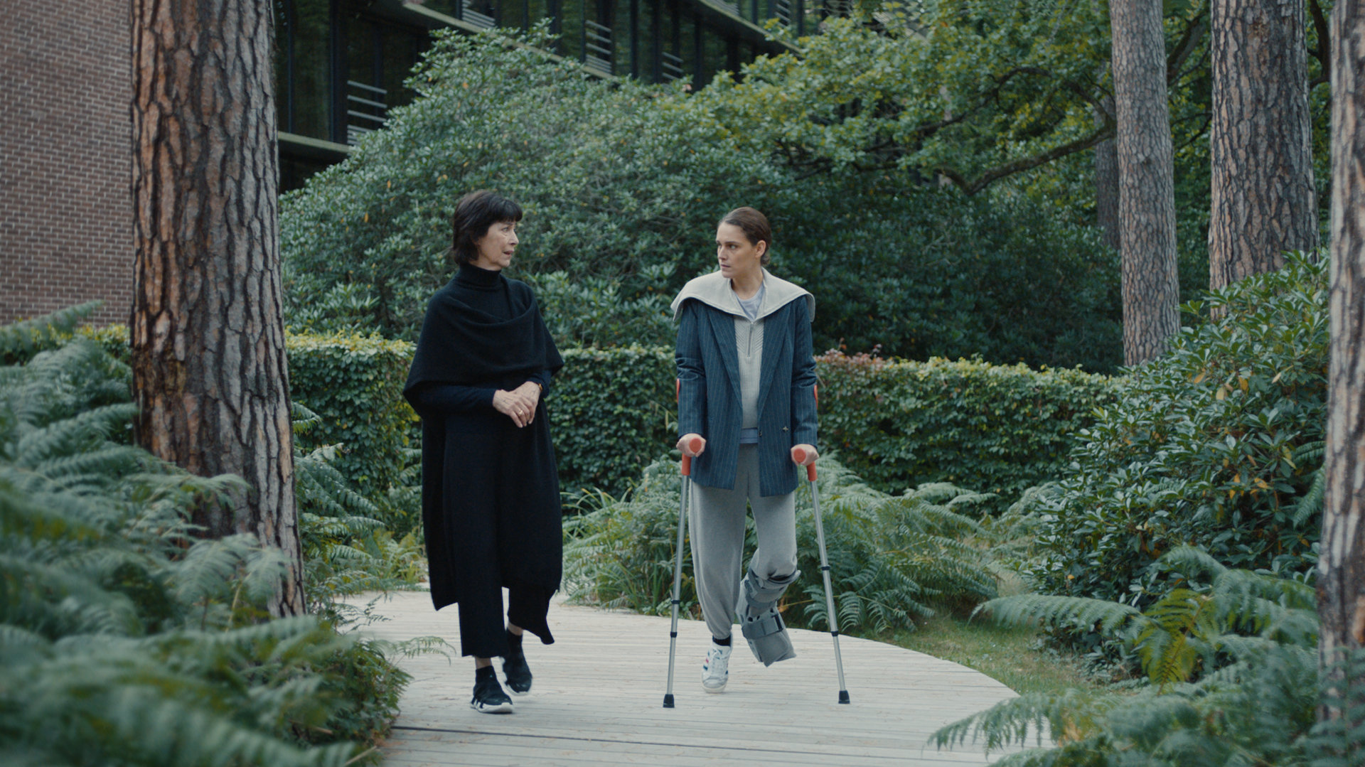 "L'Opéra - Dancing in Paris - Verführerin": Während Zoé (Ariane Labed) auf Krücken einen Waldweg entlanghumpelt, redet Diane (Anne Alvaro) auf sie ein.