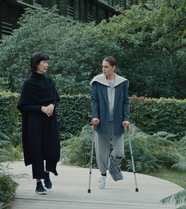 "L'Opéra - Dancing in Paris - Verführerin": Während Zoé (Ariane Labed) auf Krücken einen Waldweg entlanghumpelt, redet Diane (Anne Alvaro) auf sie ein.