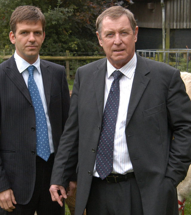 "Inspector Barnaby - Denn du bist staub": DCI Tom Barnaby (John Nettles) und sein Assistent Ben Jones (Jason Hughes) stehen zusammen auf einer Wiese neben Alpakas.
