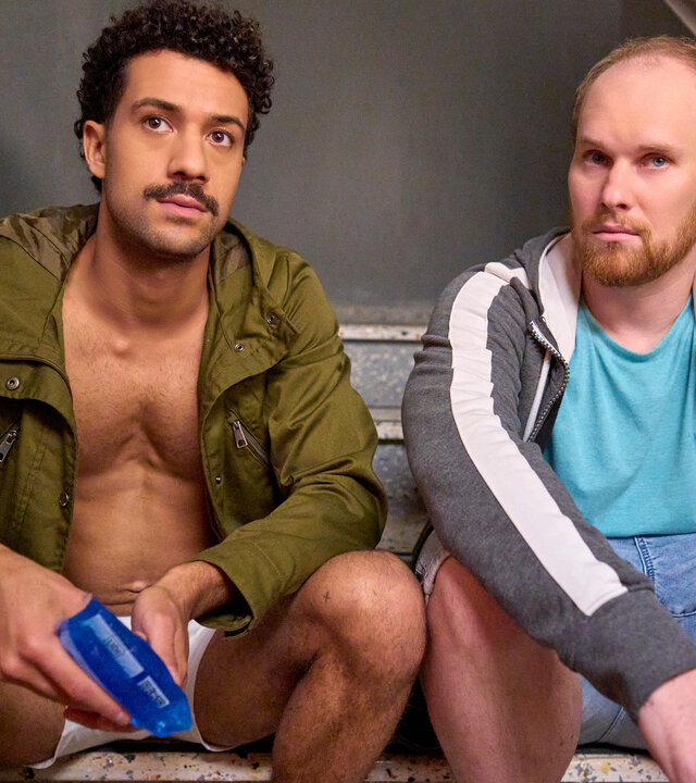 "Ich dich auch! - Die Aubergine": Yannik (Rojan Juan Barani) sitzt zusammen mit Sven (Sven Daniel Bühler) im Treppenhaus. Beide schauen sehr ernst.
