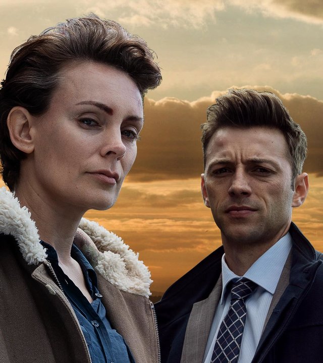 Auckland Detectives  - Tödliche Bucht: Aus dem Nichts": Detective Senior Sergeant Jessica Savage (Kate Elliott) und ihr Kollege Detective Sergeant Justin Harding (Ido Drent) in Nahaufnahme vor einem Sonnenuntergang.