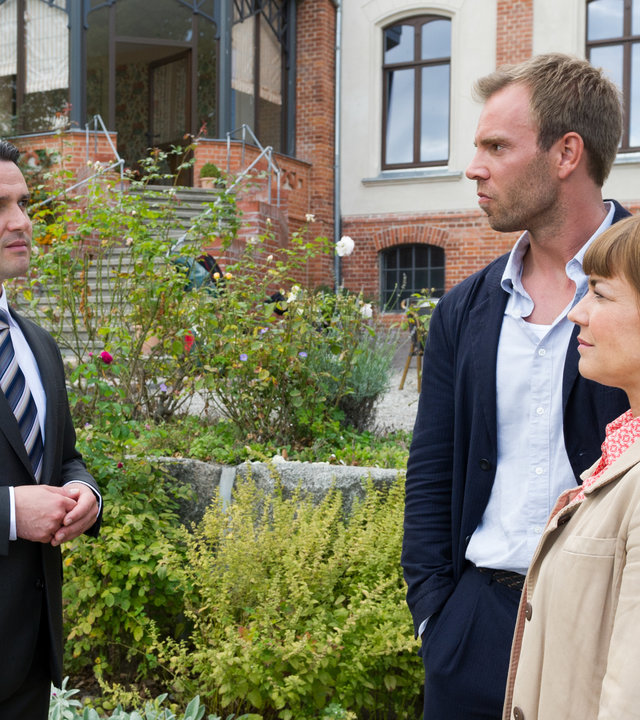 "SOKO Wismar - Femme fatale": Wolf Baumgart (Sascha Göpel), Lars Pöhlmann (Dominic Boeer) und Katrin Börensen (Claudia Schmutzler) stehen sich in einem Garten gegenüber und unterhalten sich.