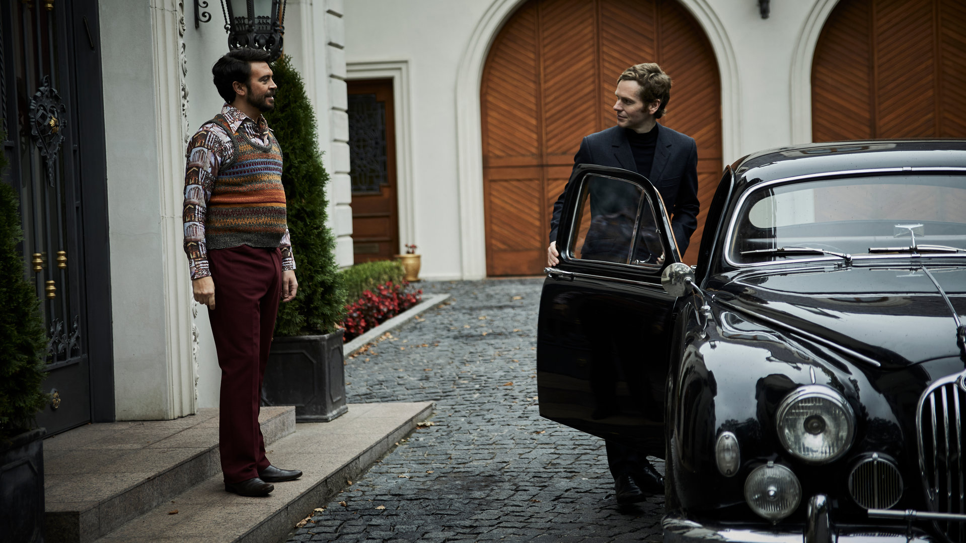 "Der junge Inspektor Morse - Lieferservice": Ludo Talenti (Ryan Gage) steht an einem Hauseingang vor Endeavour Morse (Shaun Evans), welcher in ein schwarzes Auto einsteigt.