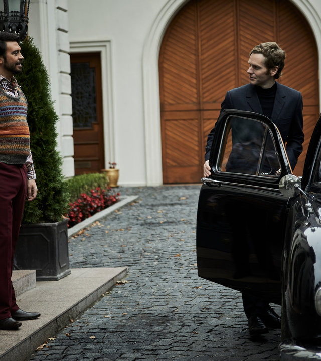 "Der junge Inspektor Morse - Lieferservice": Ludo Talenti (Ryan Gage) steht an einem Hauseingang vor Endeavour Morse (Shaun Evans), welcher in ein schwarzes Auto einsteigt.