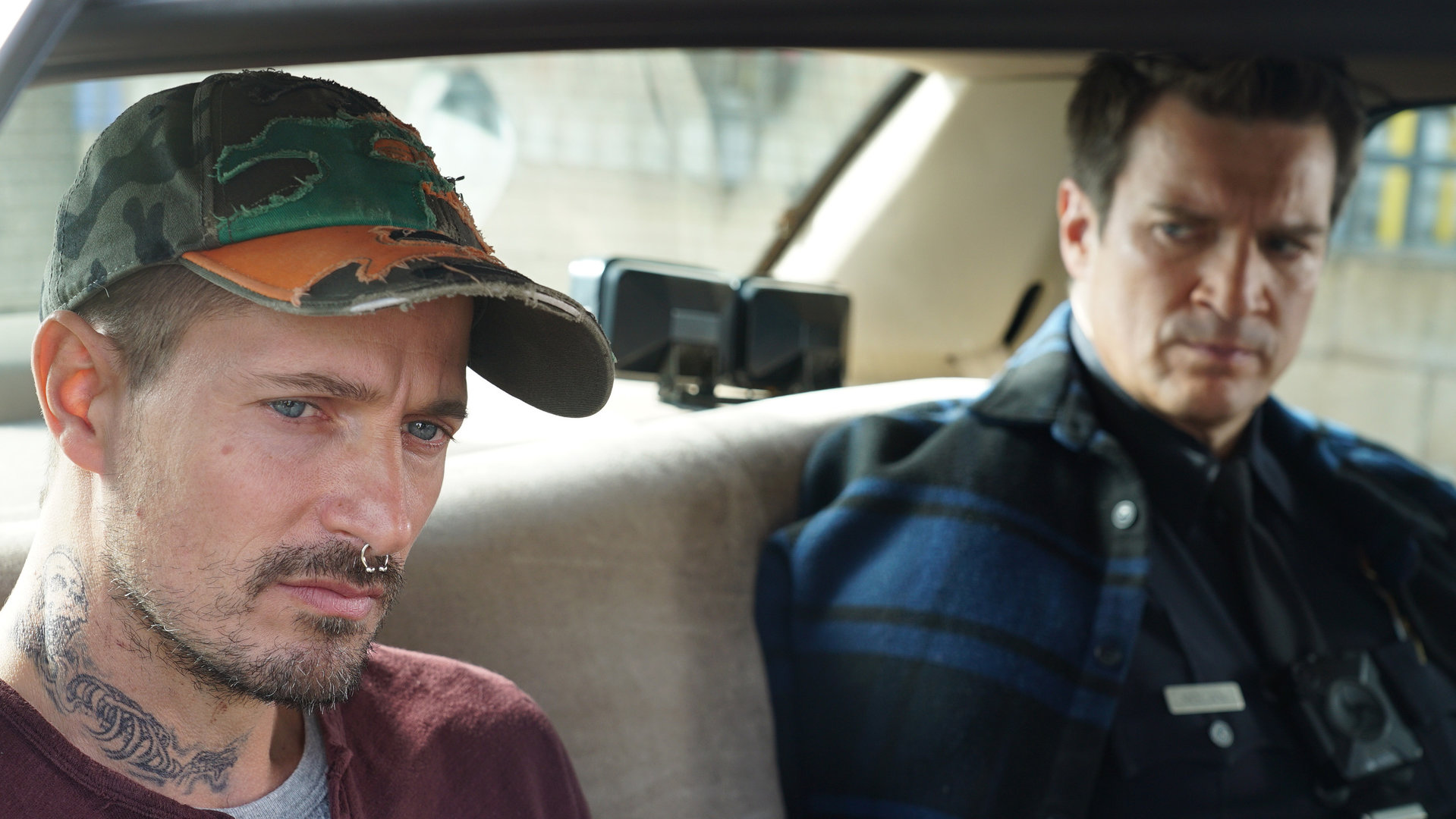 "The Rookie - Die Checkliste": John Nolan (Nathan Fillion) und Andrew Gannon (Lane Carlson) sitzen auf der Rückbank eines Autos nebeneinander. Andrew Gannon schaut nachdenklich.