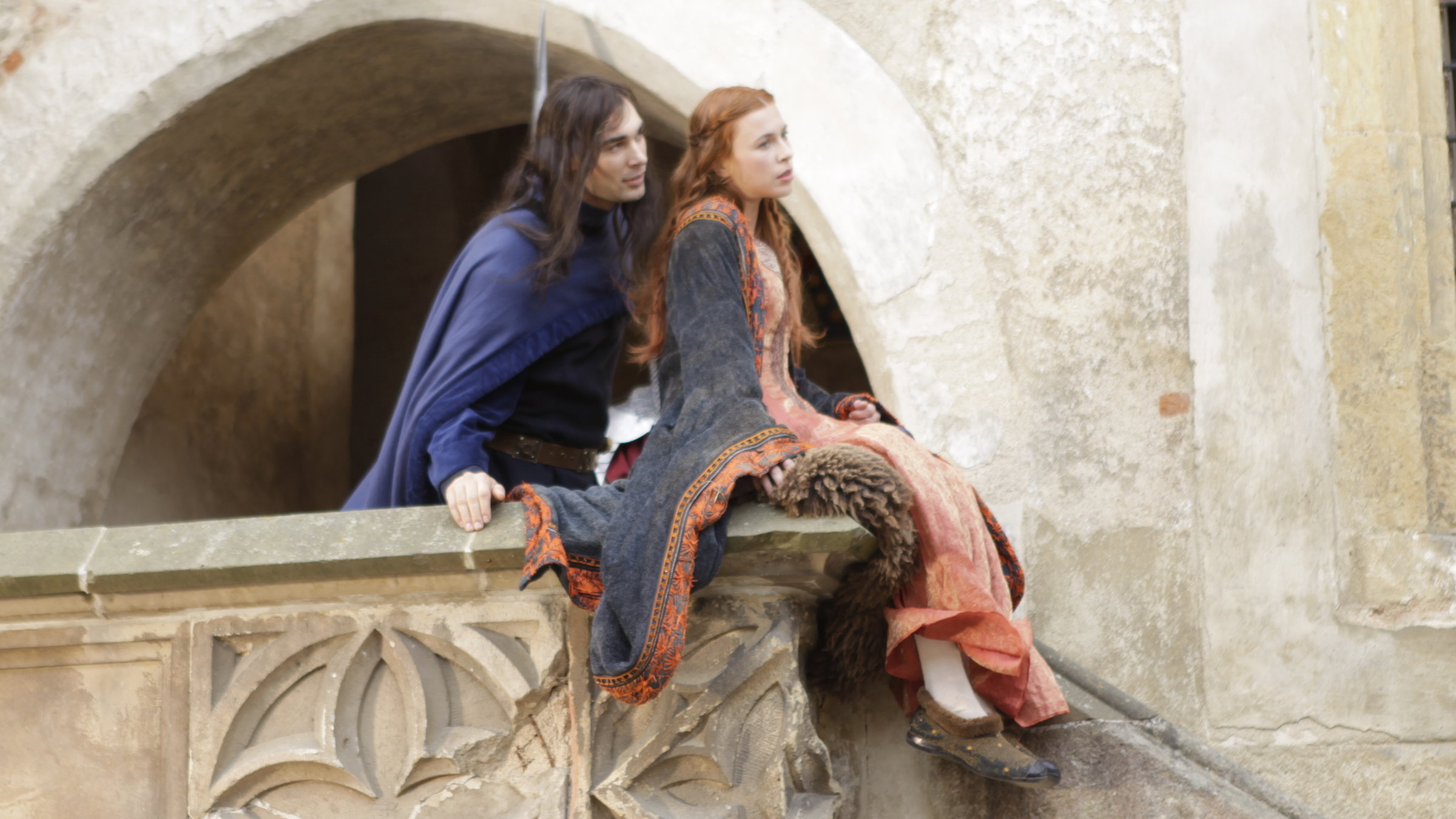 "Terra X: Die Welt der Ritter - 2. Für Ruhm und Ehre": Spielszene: Ein Ritter steht auf dem Balkon einer Burg. Auf dem Geländer sitzt seine Angebetete, zu der er sich hinneigt.