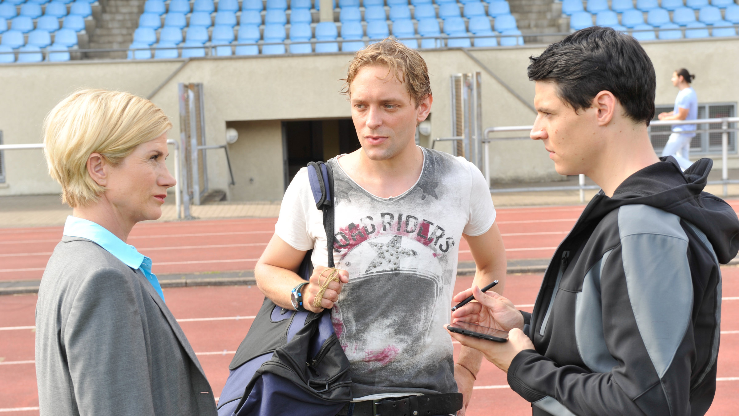 "SOKO Stuttgart - Sein letzter Pfiff": Martina Seiffert (Astrid M. Fünderich) und Rico Sander (Benjamin Strecker) vernehmen Dennis Pflieger (Florian Rummel) im Stadion auf der Aschenbahn.