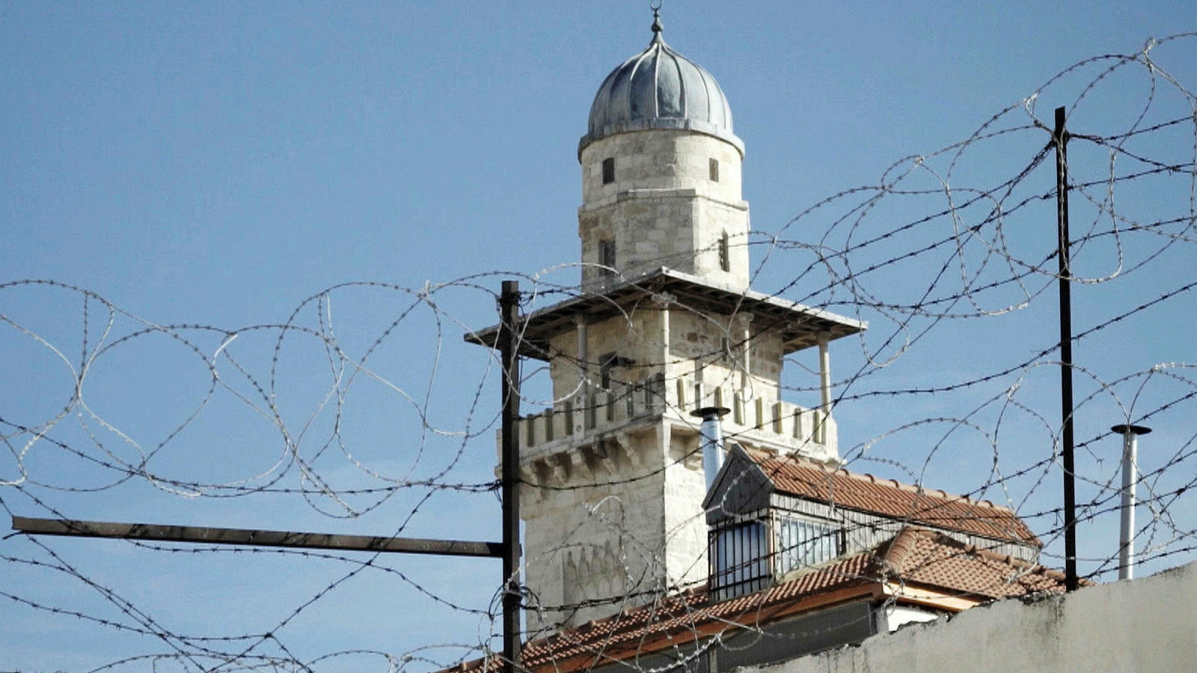 "Kippa, Kirchen und Koran: Konfliktherd Jerusalem": Stacheldraht, dahinter ein Kirchturm