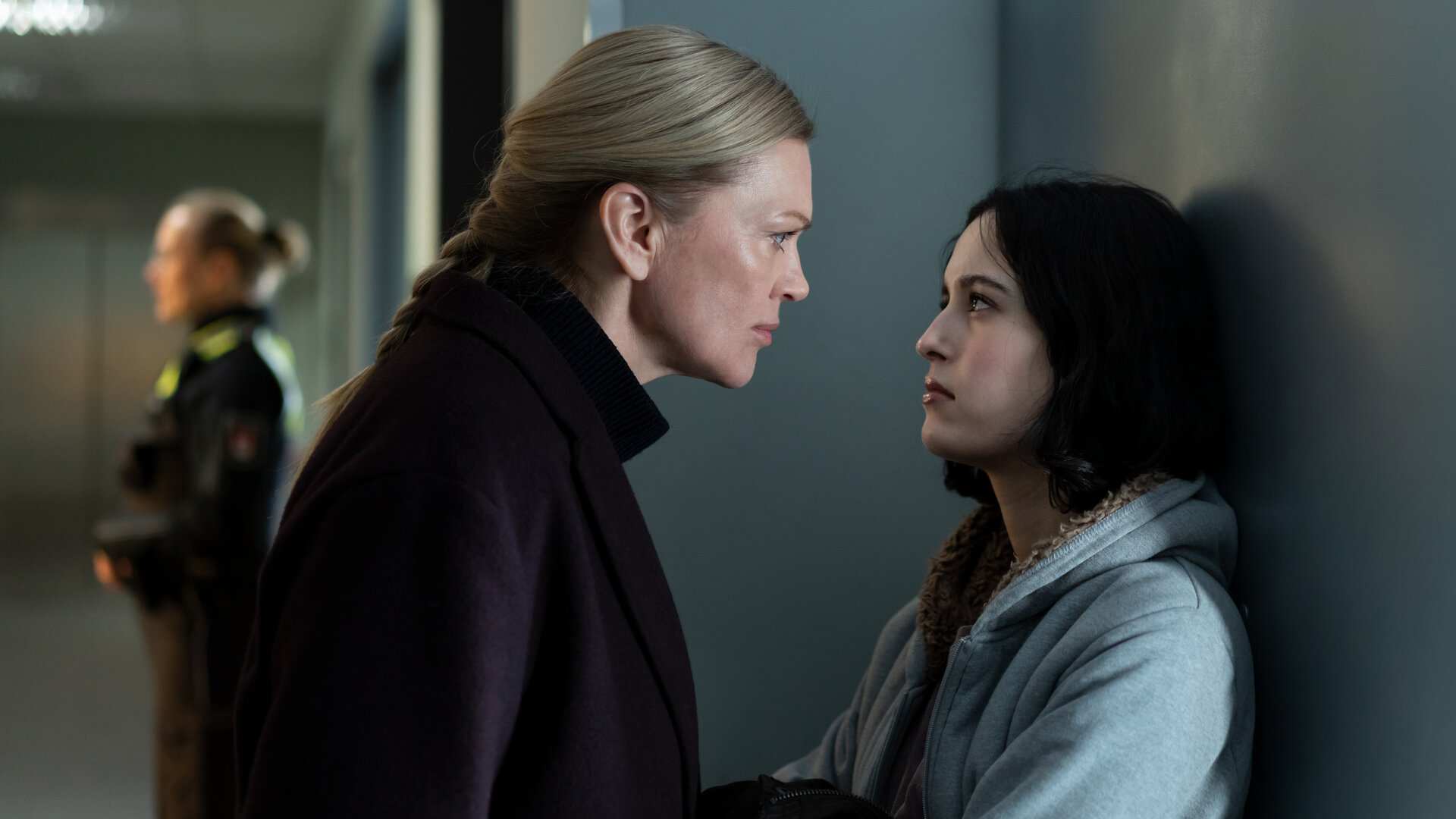 "Helen Dorn - Verdammte Familie": Helen Dorn (Anna Loos) spricht mit Tamara Jacobsen (Maya Lauterbach) auf einem Flur. Im Hintergrund steht eine Polizistin (Komparsin).
