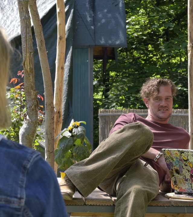 "SOKO Potsdam - Alte Freunde": Tamara (Anja Pahl) stellt Jo (Karen Dahmen) und Harry (David Bredin) draußen zur Rede. Jo und Harry sitzen auf einem Tisch mit einem Laptop vor sich. Tamara blickt zu ihnen und steht mit dem Rücken zur Kamera.