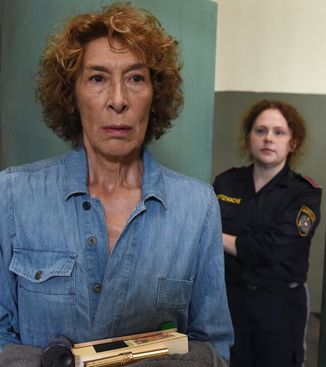 "Mama ist die Best(i)e Teil I": Gloria Almeda (Adele Neuhauser) trägt Gefängniskleidung. Sie wird von einer Justizbeamtin zu ihrer Zelle gebracht und hält einige Utensilien in Händen. Die Tür hinter ihr wird sich gleich schließen.